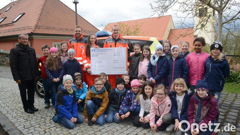 Die Kinder übergaben mit Pfarrer Pater James Mudakodil (links) an das Dreierteam der Ortsgruppe Helfer vor Ort Leon Bösl, Celina Reich und Peter Bäumler (von links) eine Spendenscheck über 765 Euro. Bild: bey