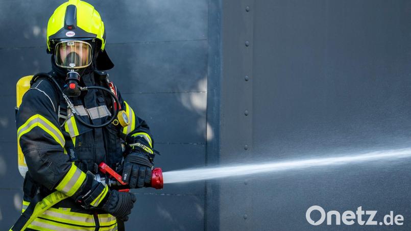Ein Mitglied der Feuerwehr beim Löscheinsatz. Symbolbild: David Inderlied/dpa