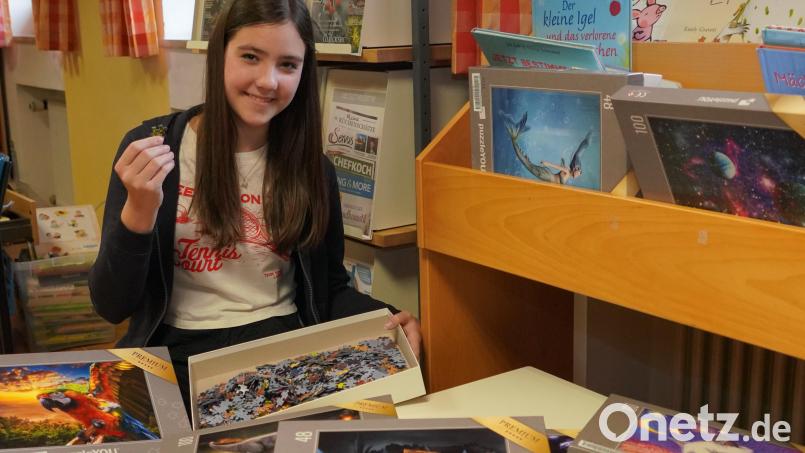 Büchereimitarbeiterin Marlene Greiner stellt das neue Puzzle-Sortiment vor. Bild: fvo