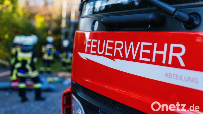 Feuerwehrleute stehen hinter einem Einsatzfahrzeug. Symbolbild: Philipp von Ditfurth/dpa