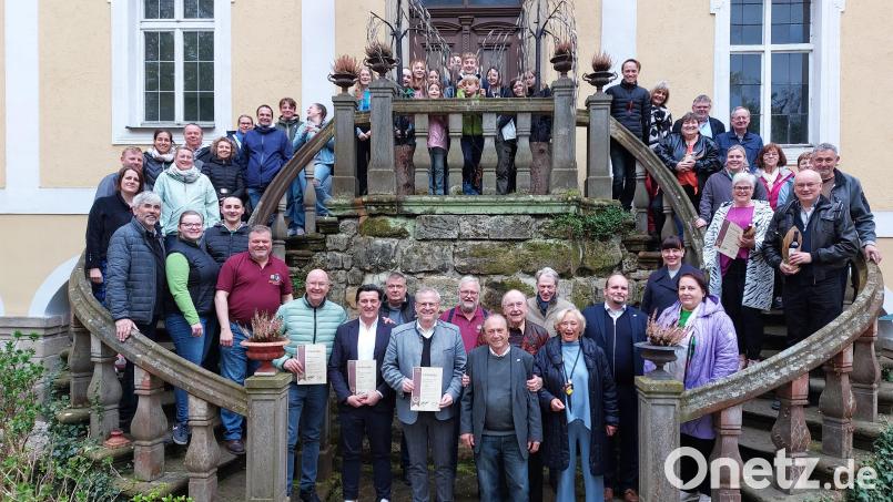 Zweiter Vorsitzender Florian Peter (rechter Treppenpfosten, hinten) vom Libourne-Verein zusammen mit den Geehrten und den französischen Austauschschülern sowie in der Mitte Oberbürgermeister Andreas Feller mit den Gründungsmitgliedern Ilse und Horst Goldfuß sowie Schlossherr Hubertus von Breidbach-Bürresheim. Bild: Kristina Borkner/exb