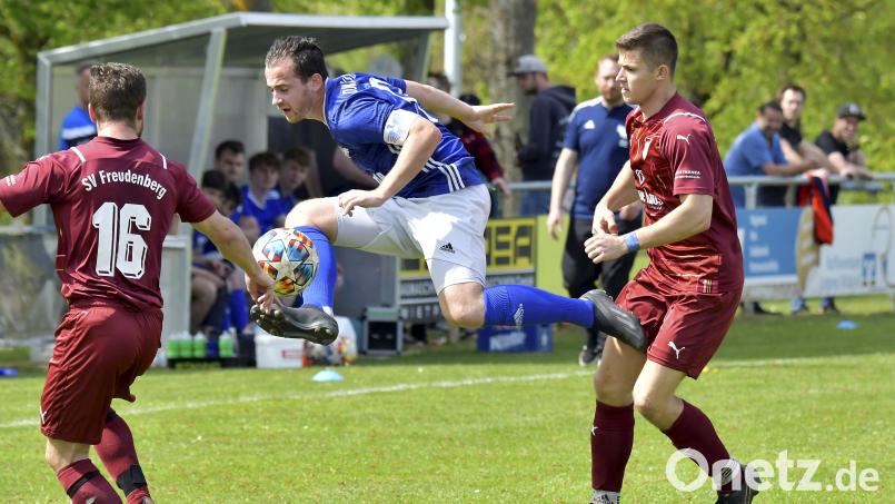 Verteidigung um jeden Preis: Mit einer artistischen Einlage bringt in dieser Szene der Ensdorfer Kapitän Stefan Grabinger (Mitte) den Ball vor Ferdinand Peter (links) und Florian Peter vom SV Freudenberg in Sicherheit. Bild: Hubert Ziegler