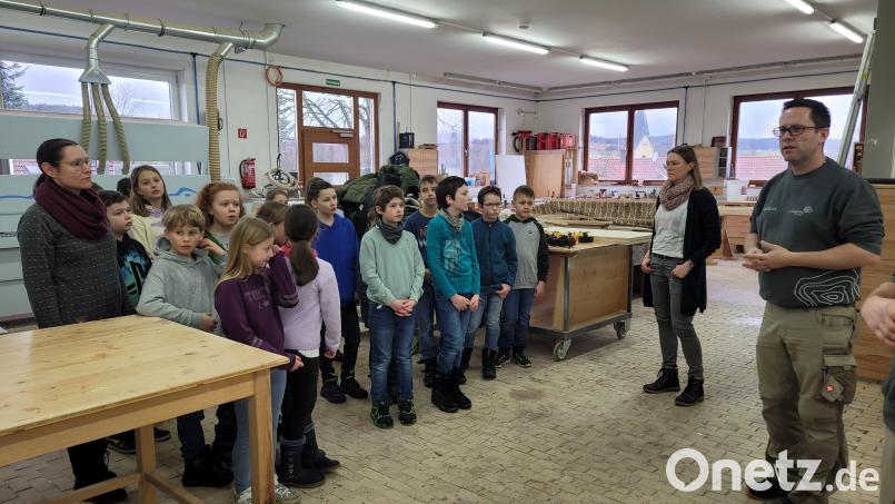 Schreinermeister Florian Danzl zeigt den interessierten Schülern, wie Holz verarbeitet wird. Bild: Ortrud Sperl/exb