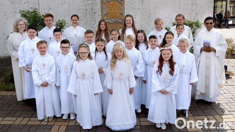 15 Mädchen und Buben der Pfarrgemeinde feiern Erstkommunion mit Gemeindereferentin Waltraud Dobmann (links), Ministranten, Lektor Willi Rupprecht (Zweiter von rechts) und Pfarrer Augustin Lobo (rechts). Bild: Foto Ott Eschenbach