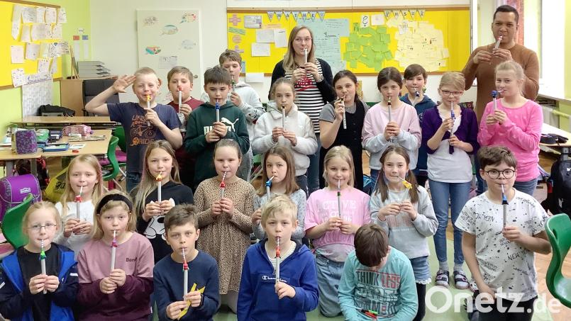 Miguel Lopez (rechts hinten) von der Kreismusikschule mit den Drittklässlern und ihren selbstgebastelten Strohhalm-Instrumenten. Bild: njn