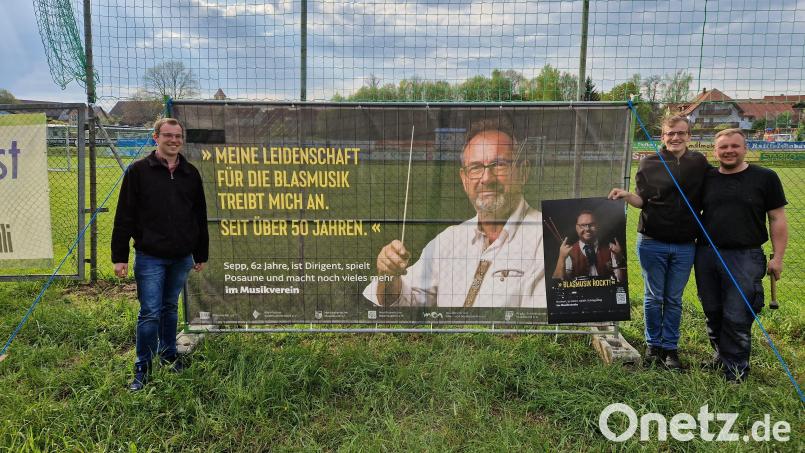 &quot;Meine Leidenschaft für die Blasmusik treibt mich seit über 50 Jahren an&quot;, versichert Kapellmeister Josef Wolfrath, der von einem Banner auf dem Altenstadter Fußballplatz strahlt. Es handelt sich um eine Imagekampagne des Nordbayerischen Musikbunds. Vorsitzender Daniel Fenzl (links) brachte das Banner mit Musikerkameraden am Montag an. Bild: dob