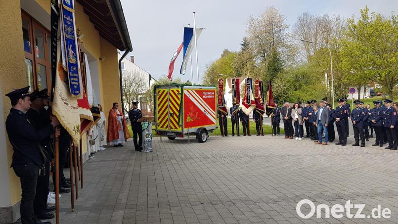 Erster Kommandant Bernhard Meiller (am Rednerpult) dankte Pfarrer Udo Klösel für die Segnung des neuen Mehrzweck-Anhängers der Feuerwehr Moosbach. Zweiter Bürgermeister Bernhard Rom (1. Reihe Fünfter von links) sprach der Wehr seinen Dank aus. Bild: gi