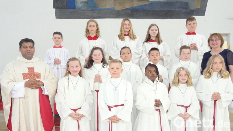 Die Erstkommunionkinder gruppierten sich mit Pfarrer Pater John (links) und Gemeindereferentin Edith Konrad (rechts) zum Erinnerungsbild. Bild: apr