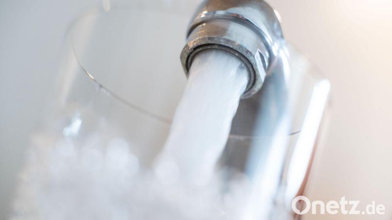 Wasser läuft aus einem Wasserhahn in ein Glas: Die Sigl-Sigras-Gruppe erhöht ihre Wassergebühren. Symbolbild: Lino Mirgeler/dpa/Symbolbild