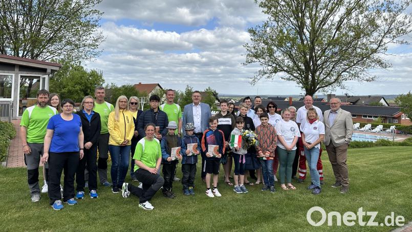 Bürgermeister Hans-Martin Schertl (hinten Mitte) überreicht der ersten Badbesucherin Rebecca Rittner einen Blumenstrauß. Die Bademeister, das Badpersonal, die Wasserwacht und die Pächter des Kiosk hoffen auf viele Sonnenstunden. Bild: Stefanie Gradl