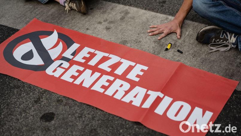 Ein Aktivist der Gruppe „Letzte Generation“ blockiert eine Kreuzung. Bild: Swen Pförtner/dpa/Symbolbild