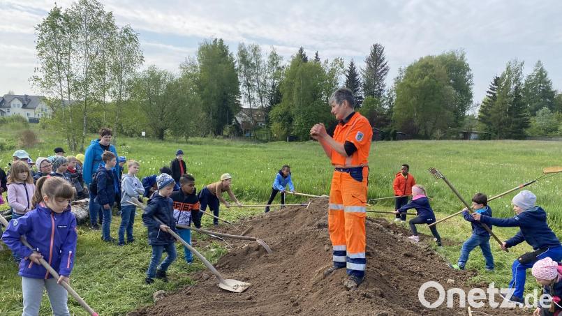 Stadtgärtnerin Rosi Rahn (Mitte) im Kreise vieler Schülerinnen und Schüler, die bei der Pflanzaktion tatkräftig mit anpackten. Bild: Marien-Grundschule/exb