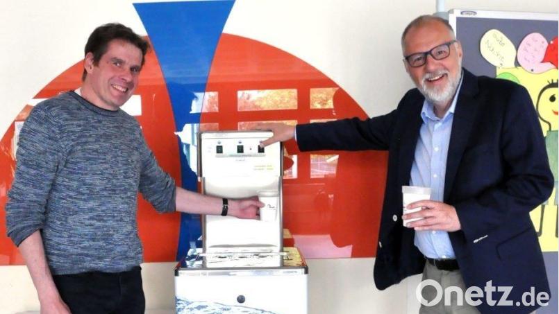 Ralph Schmitt (links), der Leiter des Sonderpädagogischen Förderzentrums, nimmt den Spender mit Stadtwerke-Geschäftsführer Frank Backowies (rechts) in Betrieb. Bild: Karoline Gajeck-Scheuck/exb