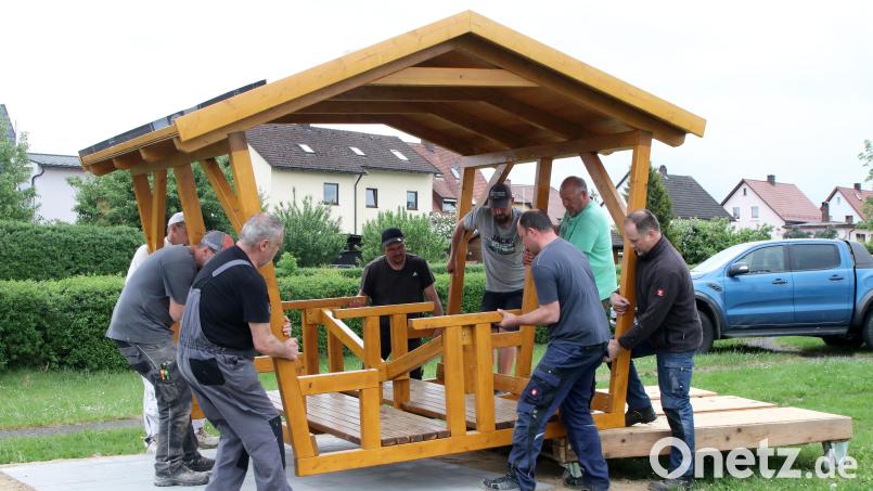 Kräftige Jungs der Flosser Siedlergemeinschaft legten am Dienstagabend mächtig Hand an und platzierten das neue schattenspendende Holzhaus für Familien und Kinder auf dem Spielplatz im Ortsteil Ziegelhütte. Bild: lst/exb