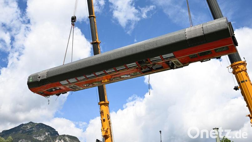 Ein Waggon wird von zwei Kränen auf die Bundesstraße gehoben. Bild: Angelika Warmuth/dpa/Archivbild