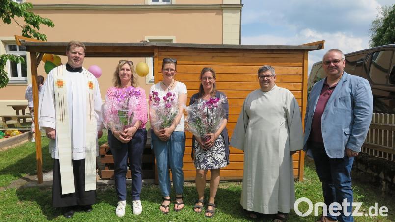 Nach der Segnung des neuen Spielehauses (im Hintergrund) dankten Stadtpfarrer Thomas Kraus (links) und Hans Stelzl von der KEB (rechts) den drei Gruppenleiterinnen Renate Pressler, Susanne Herold, Heidi Nickl (Zweite, Dritte und Vierte von links) und dem Pastoralreferenten Jochen Gößl (Zweiter von rechts). Bild: jzk