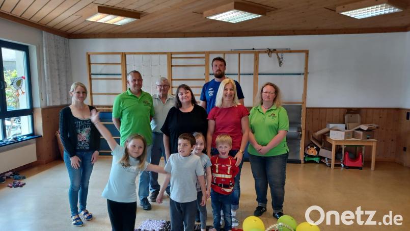 Beim Barfußlaufen über die neuen Sensorikmatten hatten die Kinder im Kinderhaus St. Marien viel Spaß. Auch Kindergartenleiterin Anita Junkunz (Vierte von links) freute sich über die Überraschung aus der Maibaumverlosung. Bild: vsr