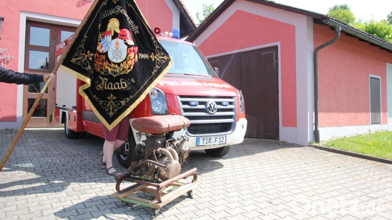 Sie sind Stolz der Feuerwehr Naab: das 1991 erbaute Feuerwehrhaus, das Feuerwehrfahrzeug, die Vereinsfahne und die im Zuge eines Tauschgeschäfts 1947 angeschaffte historische Tragkraftspitze (vorne). Bild: kro