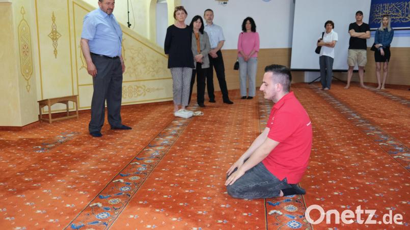 Die Muslime knien sich zum Gebet auf den Teppichboden. Sprecher Mustafa Eraslan (links) erläuterte den Besuchern die Riten in der Moschee. Bild: Hirsch