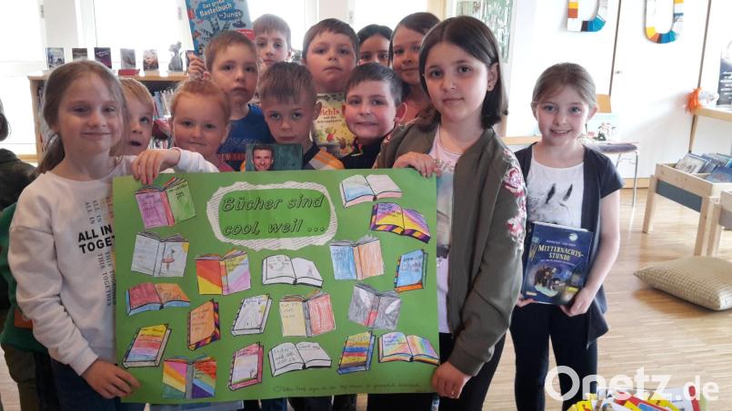 „Bücher sind cool“: Dieser Meinung sind die Kombiklassen 1/2 der Grundschule Immenreuth. Die Mädchen und Buben der 1/2c überbringen dem Team der Pfarrbücherei bei ihrem Besuch als Dankeschön ein Plakat, das die Schüler der Klasse 1/2 b nach ihrem Unterrichtsgang ins Pfarrheim gestaltet haben. Bild: Pfarrbücherei Immenreuth/exb