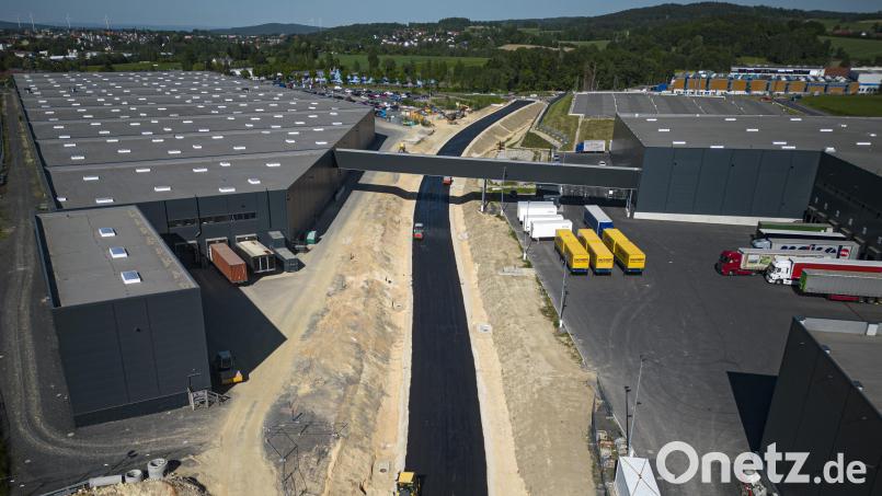 Auf Hochtouren laufen die Asphaltierungsarbeiten zwischen dem Kreisverkehr und der Bahnlinie. Links und rechts der Trasse der Umgehung stehen die Hallen des Fahrradherstellers Cube. Bild: Wolfgang Erhart/exb