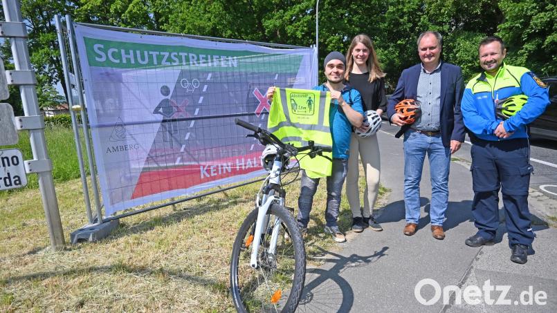 Große Banner erklären Verkehrsregeln und werben für ein gutes Miteinander im Straßenverkehr. Von links: Mose Tuygun, Cornelia Stich und Ulrich Schaller von der Stabsstelle Mobilität und Verkehr der Stadt Amberg sowie Benjamin Härtl (Verkehrssachbearbeiter bei der Polizei). Bild: Thomas Graml, Stadt Amberg/exb
