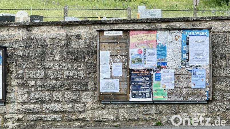 Vor dem Friedhof hängt eine der Anschlagtafeln der Gemeinde. Immer wieder kommt es vor, dass Plakate überregionaler Veranstaltungen über noch aktuelle Plakate örtlicher Veranstalter geklebt werden. Bild: Eichl