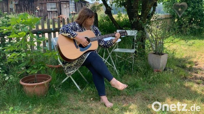 Im Garten oder auf der Bühne am Mitsingkonzert: Die Gitarre ist der liebste Begleiter von Sabine Rix. Bild: Ulrike Preißinger