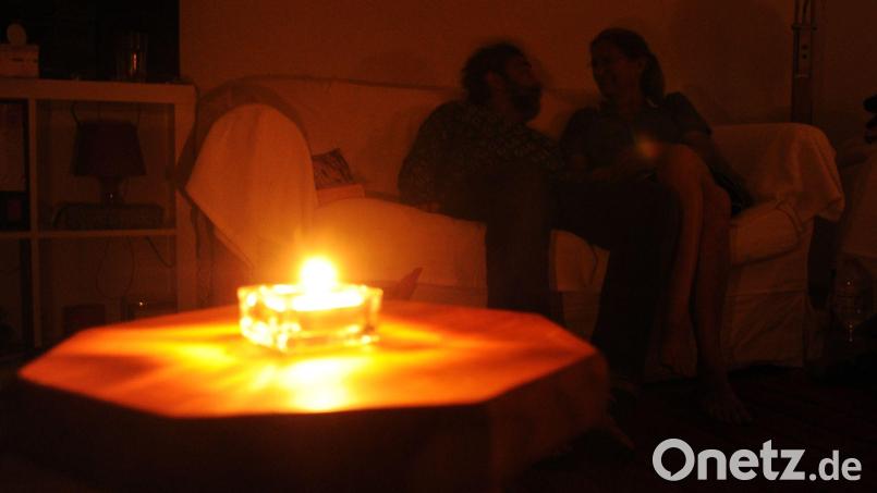 Ein Paar sitzt während eines Stromausfalls bei Kerzenschein in einer Wohnung. Dauern sie über einen längeren Zeitraum, dann sollten Notfallpläne der Gemeinden greifen. Bild: dpa | Julian Stratenschulte