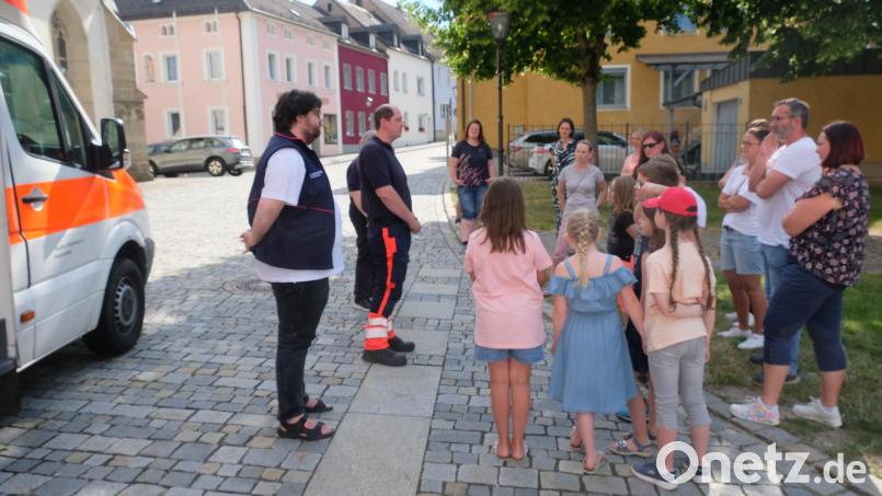 Malteser-Einsatzleiter Florian Faltenbacher (Zweiter von links) erläutert im Rahmen der Spendenübergabe den Kindern und Eltern die Idee des Projekts &quot;Herzenswunsch-Krankenwagen&quot; Bild: do