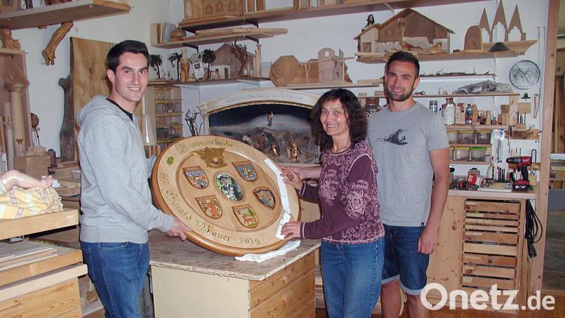 Ein Schützenkönig wartet auf seine Scheibe. In dieser verschnörkelten Schrift muss jeder Schnitt präzise sitzen, das verlangt vor allem scharfe Messer. Die Kunst des Schärfens ist eine besondere, die Gerhard Schinner perfekt beherrschte. Thomas (links) und Matthias (rechts) stehen ihrer Mutter Lisa mit Rat und Tat zur Seite. Bild: ld