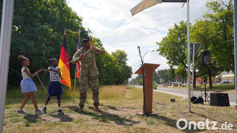 Colonel Kevin Poole laut der Mitteilung des US-Militärs, Kommandeur der US-Garnison Bayern enthüllt zusammen mit zwei Kindern das neue Straßenschild am Truppenübungsplatz Grafenwöhr. Bild: Natalie Simmel/US-Armee