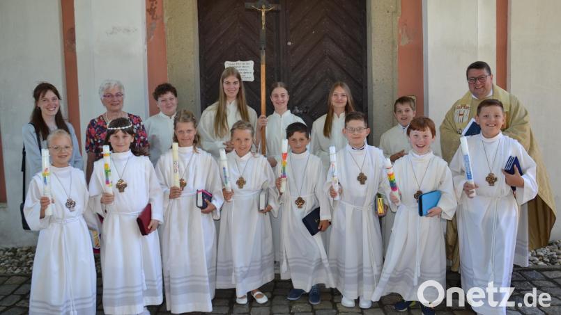 Strahlende Gesichter gibt es bei der Erstkommunionfeier mit Pfarrer Udo Klösel in der Wieskirche. Mit dabei die Schulleiterin Ulrike Uhlemann und Lehrerin Miriam Höcherl (Erste und Zweite von links). Bild: gi