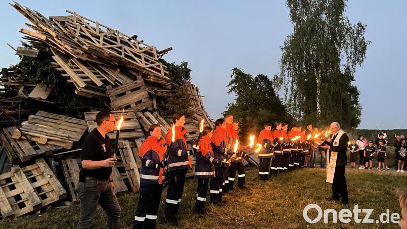 Pfarrer Herbert Rösl segnet das Johannisfeuer am Pfarrerberg. Bild: Feuerwehr Teunz/exb