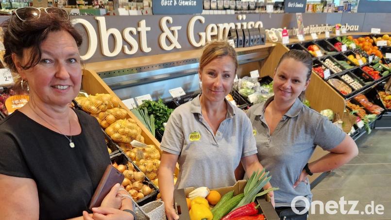 Lebensmittel retten mit „Too good to go“: Kundin Claudia Klee (links) und die beiden Schwandorfer Denns-Mitarbeiterinnen Melanie Schmid (Mitte) und Marina Berger (rechts) mit dem Obst-Gemüse-Paket. Bild: Thomas Dobler