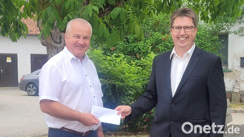 Bürgermeister Josef Deichl bekommt das Geld von Stiftungsvorstand Martin Zimmermann (rechts) überreicht. Bild: Gemeinde Schmidgaden/exb