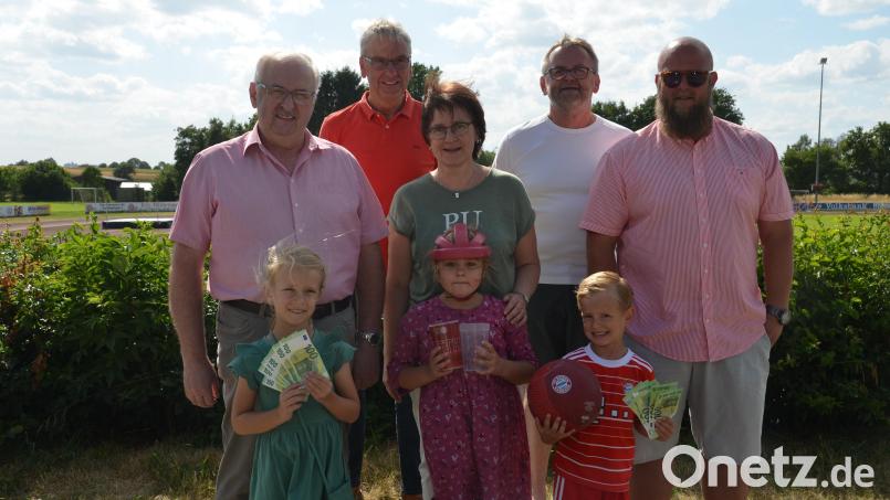 Charlotte (links) und Anton (rechts), die Kinder von Sebastian Sevens (rechts) überreichen die Spendensumme in Höhe von 1200 Euro aufgeteilt an die Kinderkrebshilfe mit Herbert Putzer (links) und HPZ-Lehrerin Christa Riedel (Mitte) mit Leonie Arlt (vorne). Sevens, Hubert Schleicher (Zweiter von links) und Stefan Schäftner (Zweiter von rechts), große Fans des FC Bayern, haben Mehrwegbecherpfand gesammelt und nun an die beiden Spendenempfänger übergeben. Bild: dob