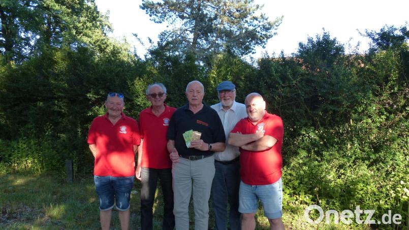 Der Präsident des FC Bayern-Stammtisches „Mia san mia“ aus Pirk, Norbert Helgath (Zweiter von links), überreicht an Josef Gebhardt (Mitte) von der Tafel in Weiden eine Spende. Bild: hme