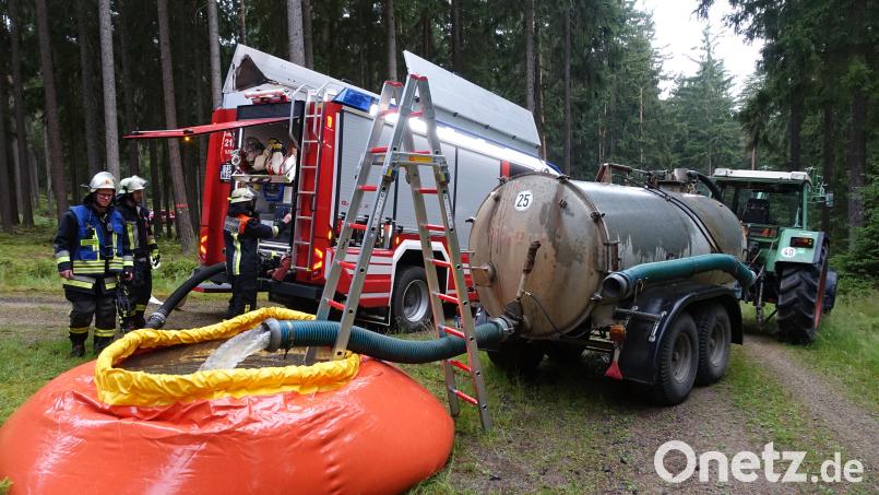 Ein Faltbehälter wurde mit Wasser gefüllt, das mit Hilfe mehrerer Güllefässer im Pendelverkehr herbeigeschafft wurde. Hier im Bild zu sehen sind der Traktor und das Fass der Stadt Waldsassen, die extra für diesen Zweck angeschafft wurden. Dahinter steht das neue Tanklöschfahrzeug der Feuerwehr Waldsassen. Bild: flm
