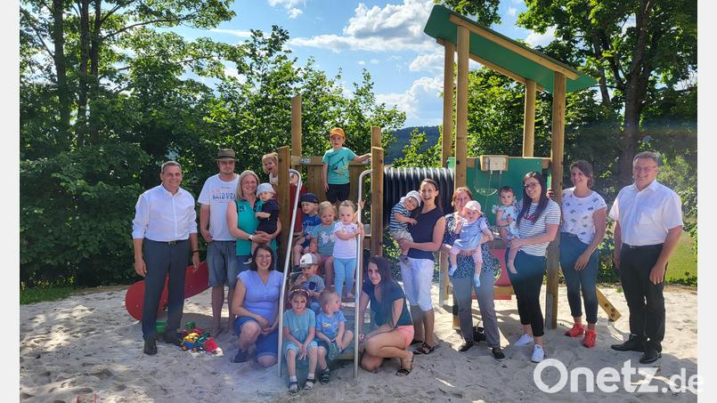 Die Kinder nehmen den neuen Kletter- und Rutschturm am Spielplatz Fuchsberg gleich in Beschlag. Bürgermeister Norbert Eckl (links) wünscht den Familien viel Spaß am Platz. Bild: Eckl