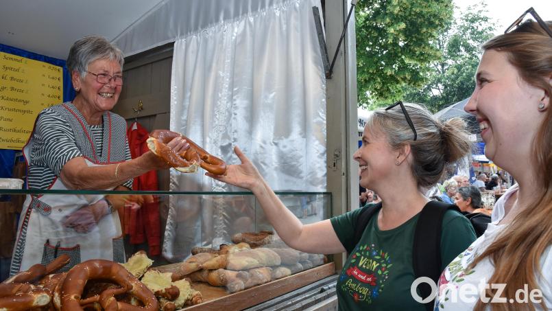 Eine Breze, die muss doch vegan sein? Nicht unbedingt, erklären Verena-Sophia Schneider und Eveline Hackenberg (von rechts) bei ihrem Rundgang übers Amberger Bergfest. In diesem Fall aber ist die Breze vegan. Bild: Stephan Huber