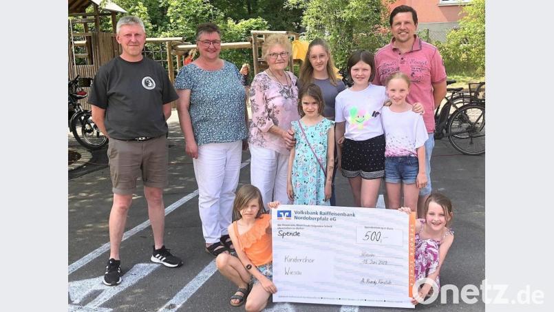 500 Euro stellte der Al-Bundy-Fanclub, vertreten durch Oliver Sturm (rechts) und Thomas Dürnhofer (links), dem Wiesauer Kinderchor zur Verfügung. Der Einladung zum Spendentermin folgten Vorsitzende Birgit Sailer (Zweite von links), Chorleiterin Christa Holm (Dritte von links) und ein Teil der Chorkinder. Bild: wro