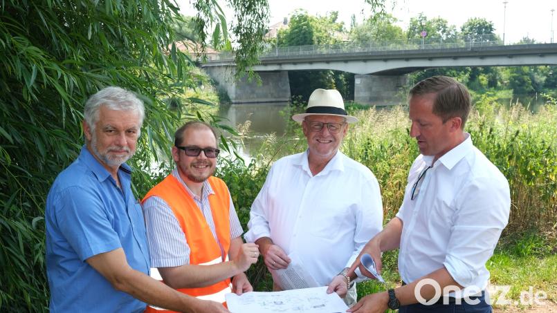Baudirektor Tobias Bäumler, Oberbürgermeister Andreas Feller, Bauoberrat Hannes Neudam und städtischer Sachgebietsleiter Roland Stehr (von rechts) erläuterten die Pläne für den Abriss der alten Naabbrücken (Hintergrund) und den Bau neuer Übergänge. Bild: Hirsch