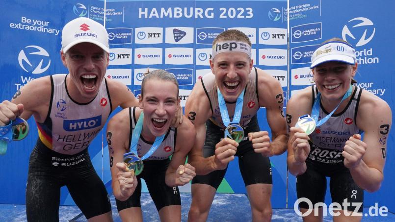 Die neuen Triathlon-Mannschafts-Weltmeister vom Team Deutschland: (von links) Tim Hellwig, Annika Koch, Simon Henseleit und Laura Lindemann jubeln mit ihren Goldmedaillen nach der Siegerehrung Bild: Marcus Brandt/dpa