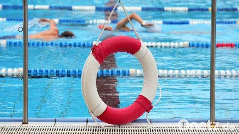 Ein Rettungsring hängt in einem Freibad am Rand des Beckens. Bild: Soeren Stache/dpa