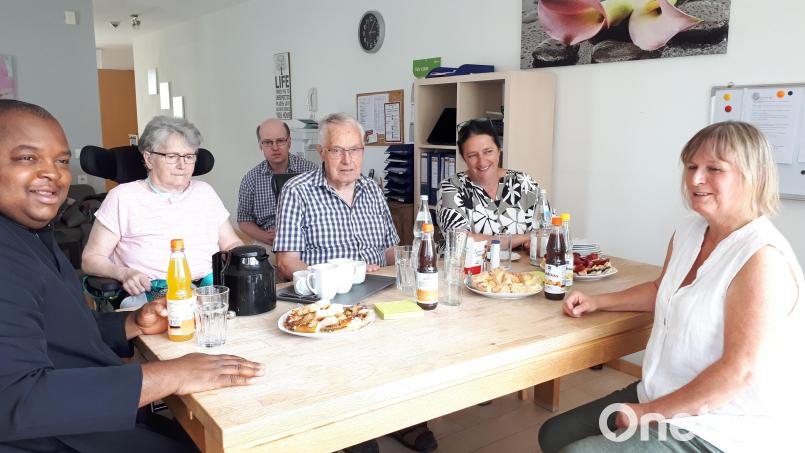 Pfarrvikar Gerald, Karin und Karl Rothenaichner, Sandra Dittebrand und Katrin Dietz (von links) nach der ökumenischen Andacht an der Kaffeetafel im Wohnzimmer, im Hintergrund der Sohn einer weiteren Bewohnerin. Bild: pz