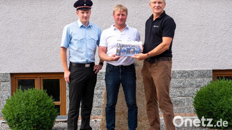 Johann Baumer (rechts) übergibt das erste Fotobuch an Stefan Prey und Markus Schiesl, (von links). Bild: Prey/exb