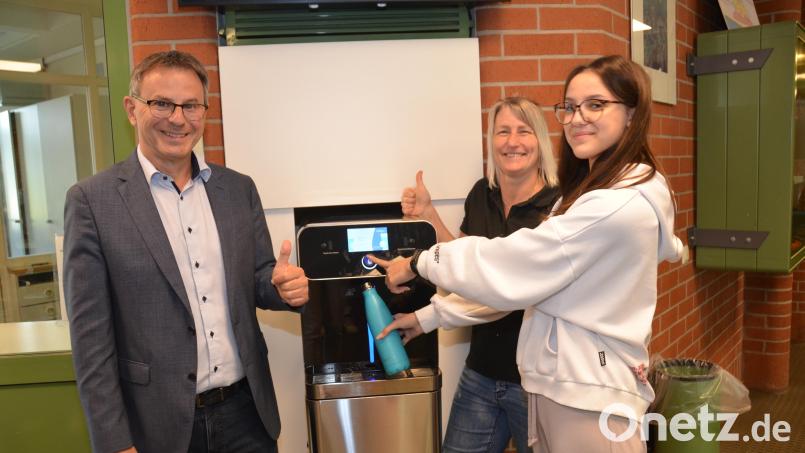 Schülersprecherin Valentina Hammer (rechts) zapft im Beisein der Vorsitzenden des Fördervereins der Mittelschule, Anja Schaller, und Rektor Hubert Reil frisches Sprudelwasser in eine Trinkflasche. Das ressourcenschonende Gerät kommt bestens bei den Schülern an. Bild: dob