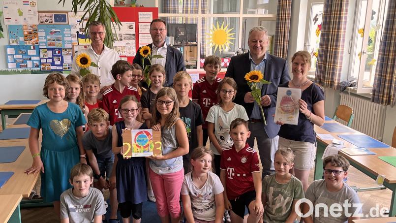 Die Schüler der Grundschule Ehenfeld um Lehrerin Sophie-Maria Högl (rechts) bekommen die Auszeichnung Energieschule. Für die Ehrengäste Bürgermeister Hermann Falk, Florian Junkes vom ZEN-Förderverein und Landrat Richard Reisinger (von links) hatten die Kinder Sonnenblumen parat. Bild: Christine Hollederer/exb