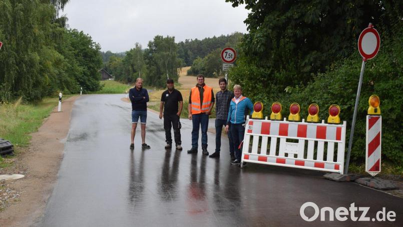 Bürgermeister Markus Schiesl (rechts) räumt die Absperrung beiseite und gibt die Straße wieder für den Verkehr frei. Bild: bnr